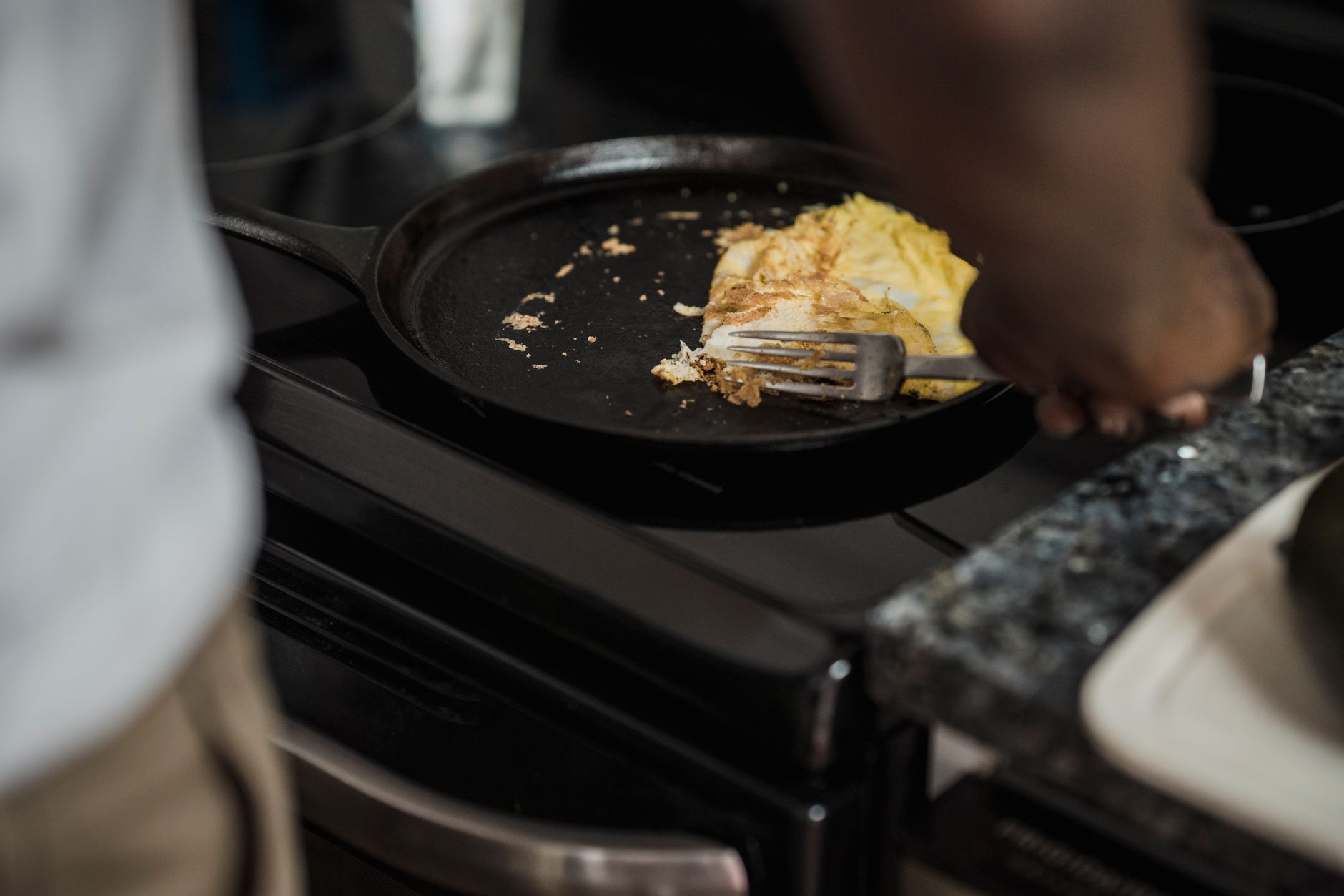 A cast iron skillet on a stove with cooked food inside
